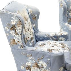 Pair of Queen Anne wingback armchairs, high back over out-swept arms, raised on ball-and-claw feet, upholstered in sky-blue ground floral chintz loose upholstery with pleated skirt and squab cushion