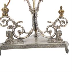 Silver plated Egyptian Revival lamp, with scrolling columns, on a trefoil base, surmounted by three sphinxes, with mask feet, H60cm