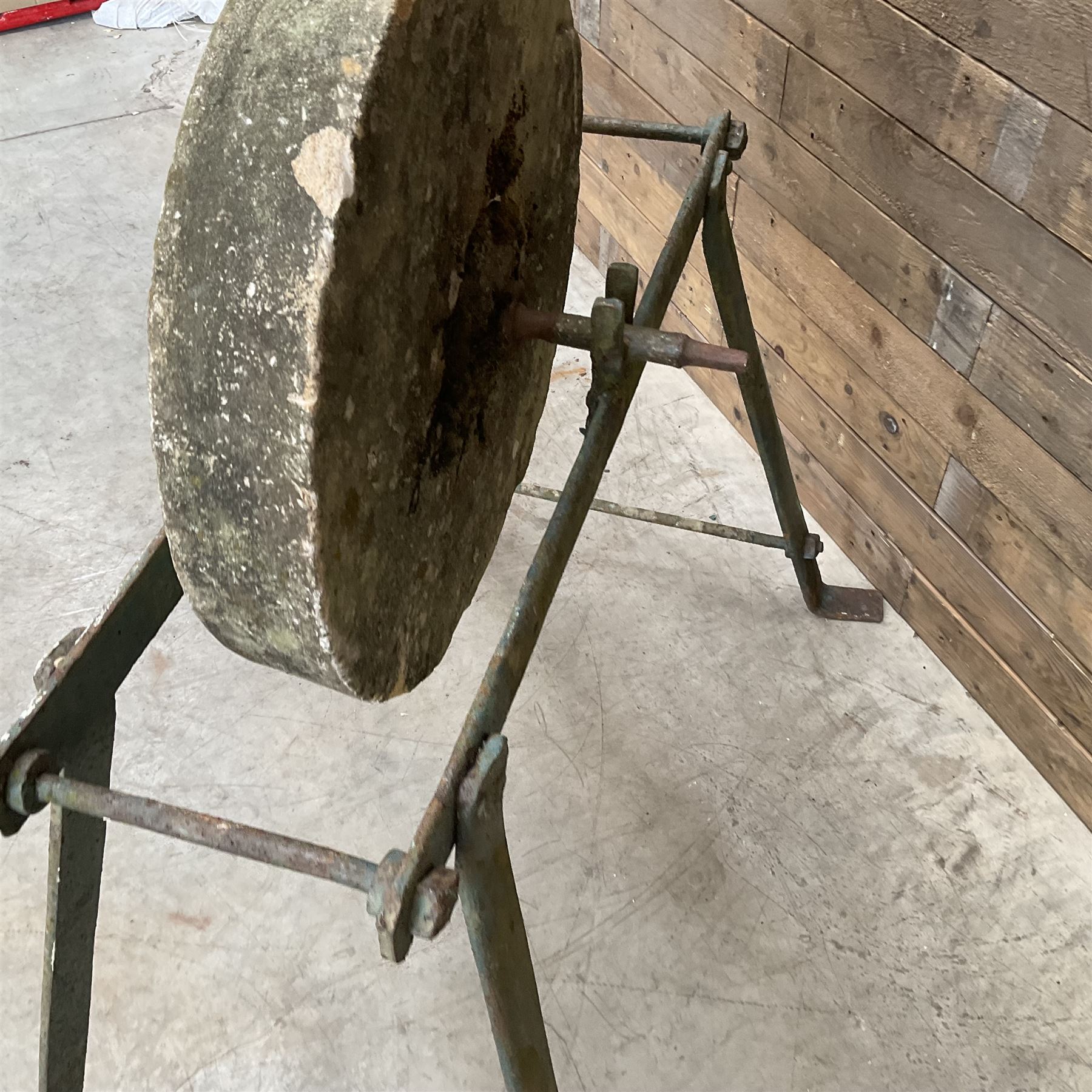 Vintage grindstone sharpening wheel mounted on metal stand, and a cast iron water pump
