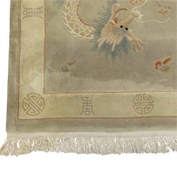 Chinese wool rug, the pale grey central field decorated with two stylised dragons, flaming pearls and cloud scrolls, within a cream border of shou medallions and geometric motifs, with cotton fringe ends