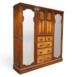 Edwardian figured walnut triple combination wardrobe, moulded cornice above a three part wardrobe, central section with figured walnut panelled doors, above two over three drawers, flanked by mirrored doors enclosing hanging hooks, raised on a plinth