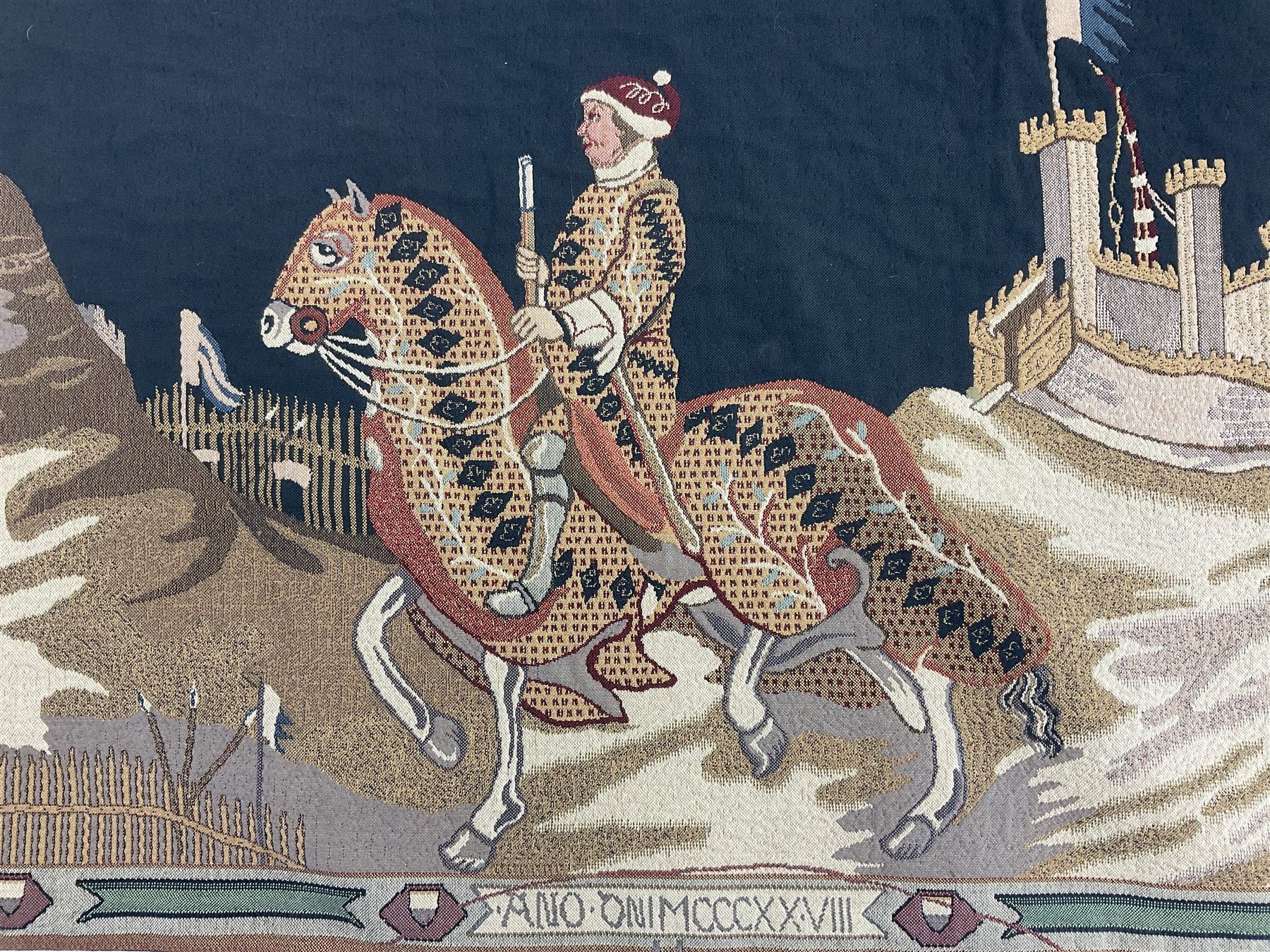 Three tapestries comprising 20th century wool tapestry panel of a medieval nobleman upon a horse with a castle in the distance, together with a smaller tapestry depicting The English Coat of Arms, both hung on rails, and further depicting village scene, largest approx 132cm x 95cm