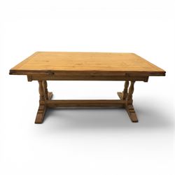 Traditional oak refectory dining table, fitted with draw leaves to either end extending to 257cm, on twin turned and block supports united by a stretcher, terminating in shaped trestle feet