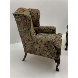 Matched pair early 20th century Queen Anne style wingback armchairs, walnut framed, sprung seats with seat cushions upholstered in needle work cover, shell carved cabriole front feet