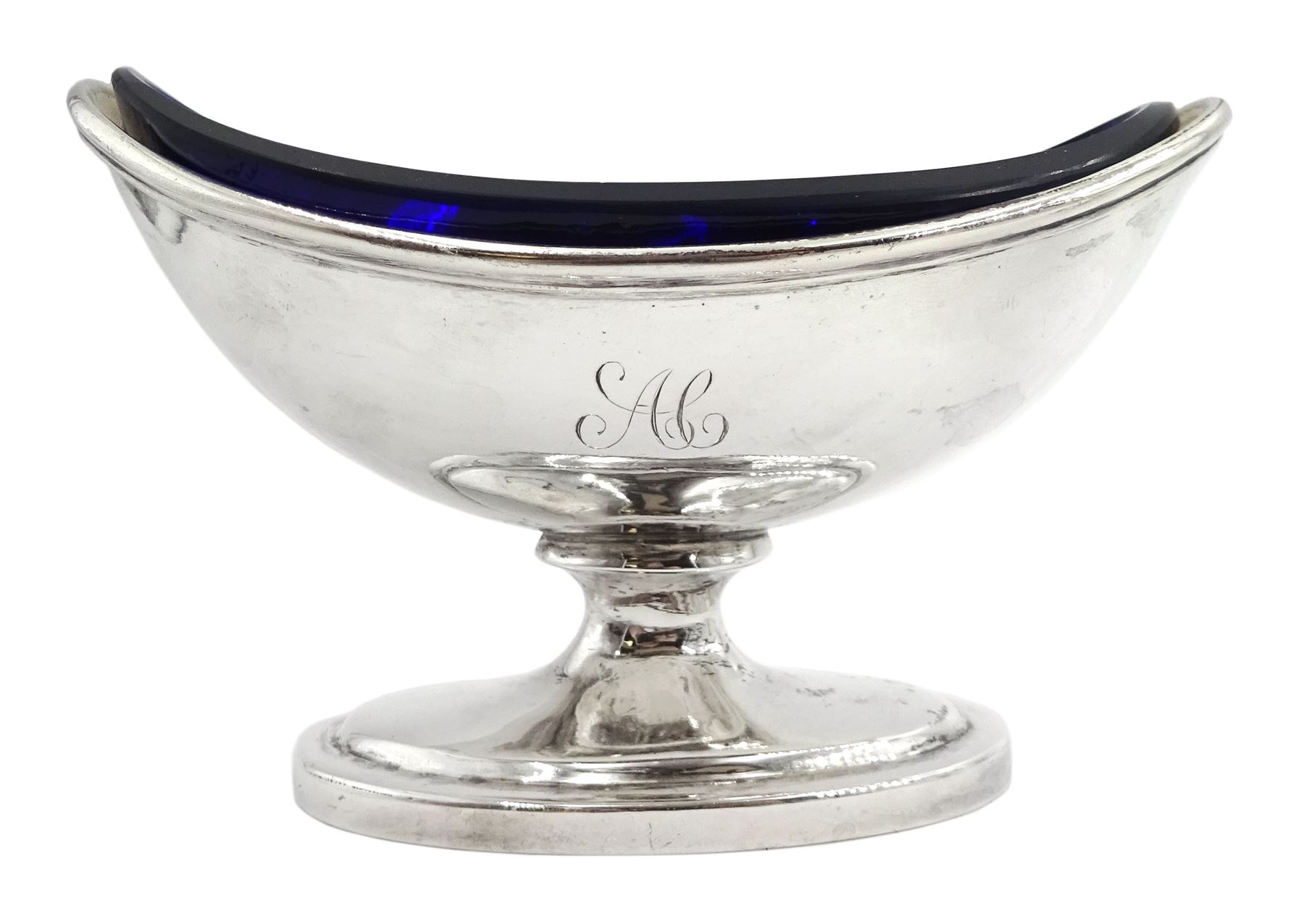 Set of four George III silver pedestal table salts, of navette form with gilt interiors and blue glass liners, hallmarked Solomon Hougham, London 1802 and 1803, together with a set of four George III Old English pattern salt spoons with gilt bowls, hallmarked London 1797, maker's mark WS, salts H6.5cm L10cm, gross weight exclusive of liners 11.51 ozt (358 grams)