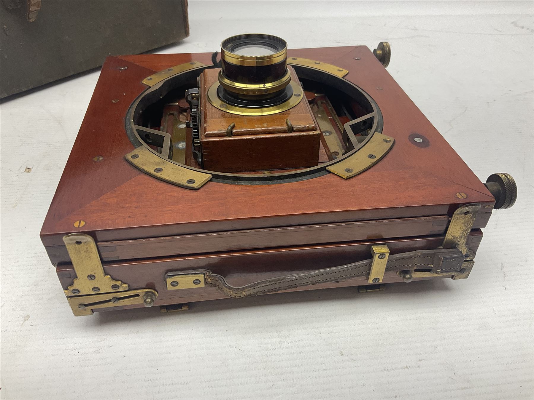 Folding plate camera in mahogany and lacquered brass, with Rapid Symmetrical Reetigmat len and two dark slides in canvas case