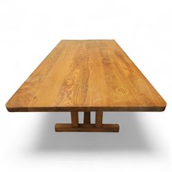 Treske of Thirsk - solid oak refectory dining suite, rectangular top with chamfered edge over trestle base united by a central stretcher, together with six matching slat back dining chairs, including two carvers, with panelled seats and square legs united by stretchers (H 87cm, W 62cm, D 57cm)