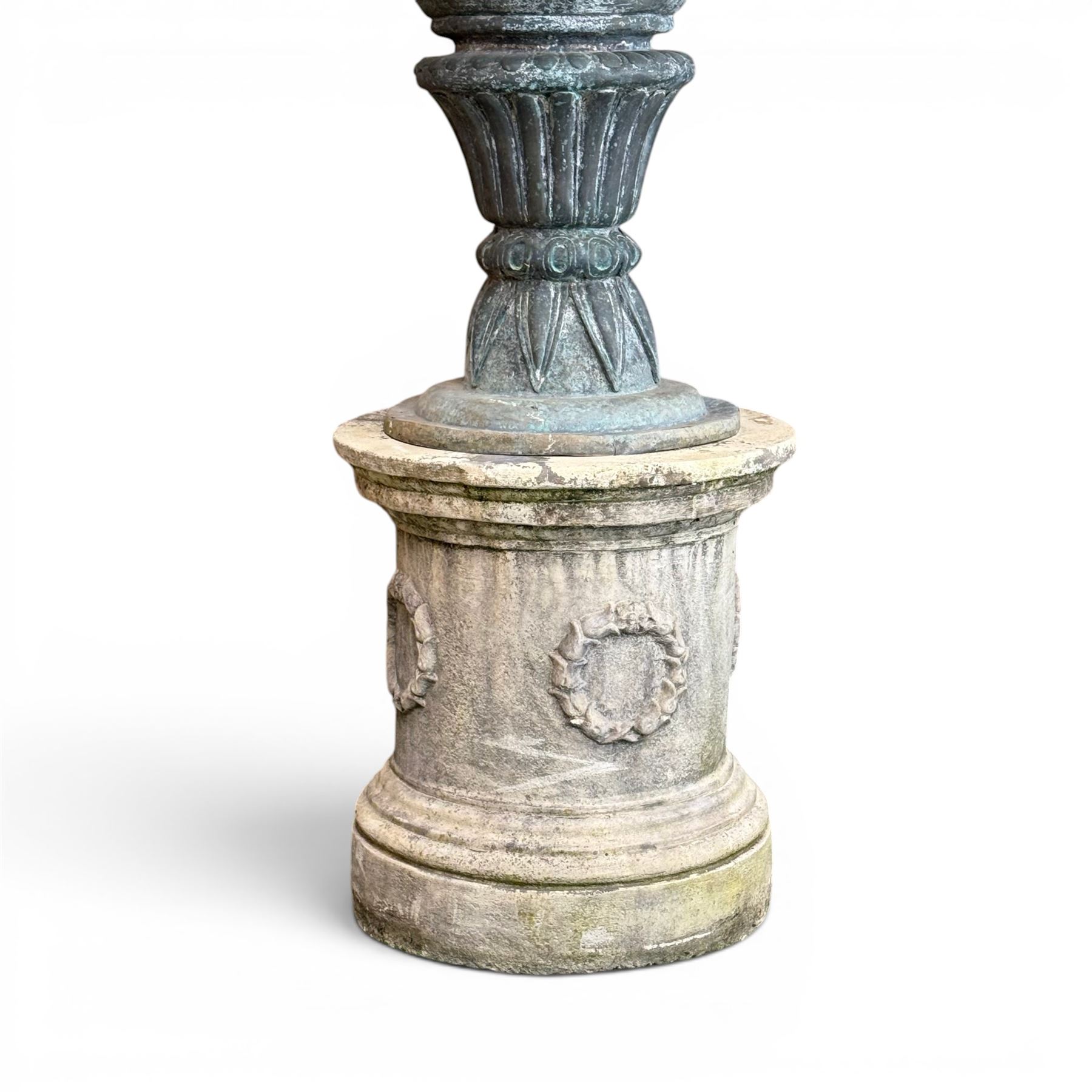 Large impressive Classical cast bronze center-piece urn, twin scroll handles with grape garlands, cherub masks and relief detail, raised on a circular cast stone pedestal with moulded detail