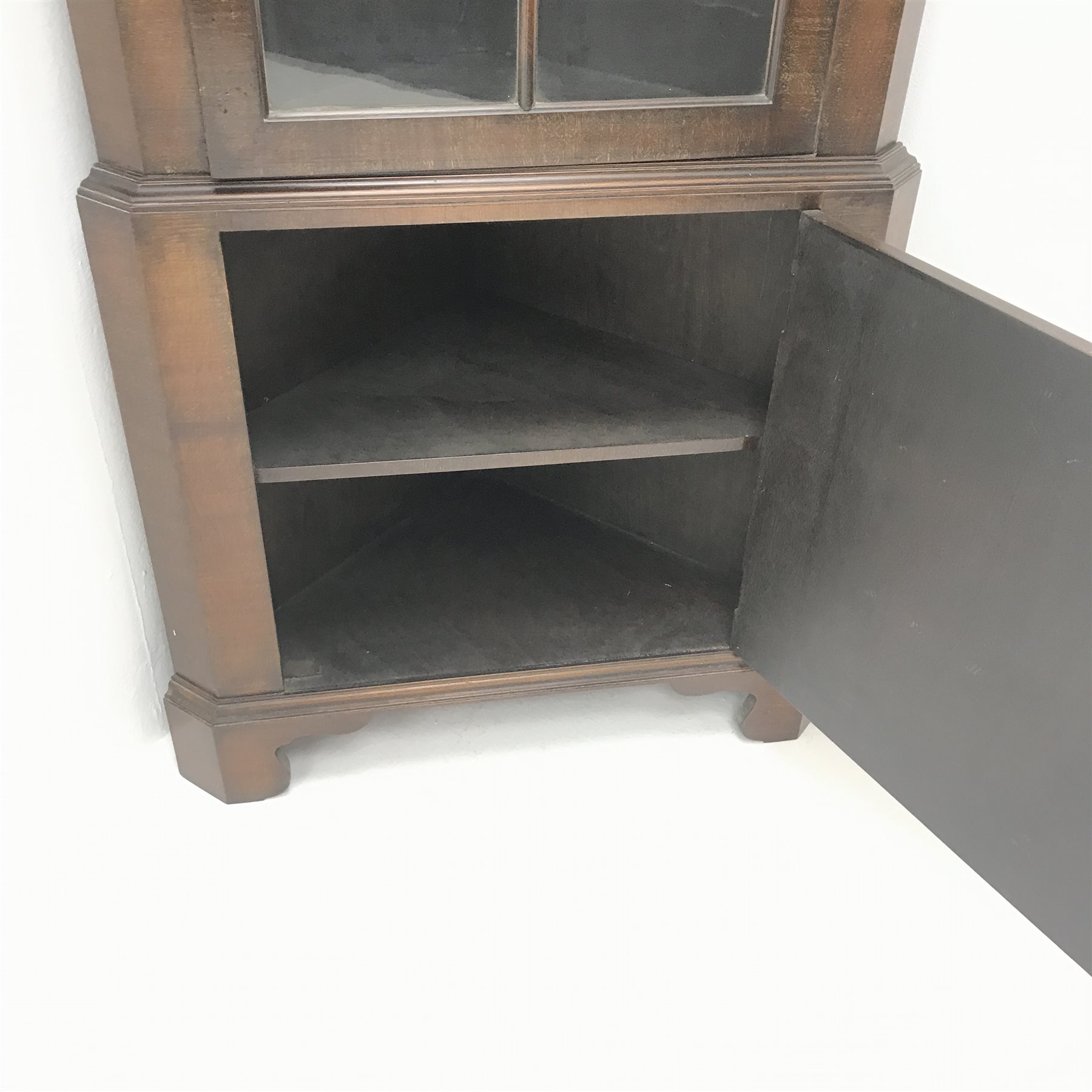 20th century walnut corner cabinet, arched swan neck pediment with central finial, single glazed door, two shelves, cupboard door, shaped bracket supports, W69cm, H191cm, D38cm  