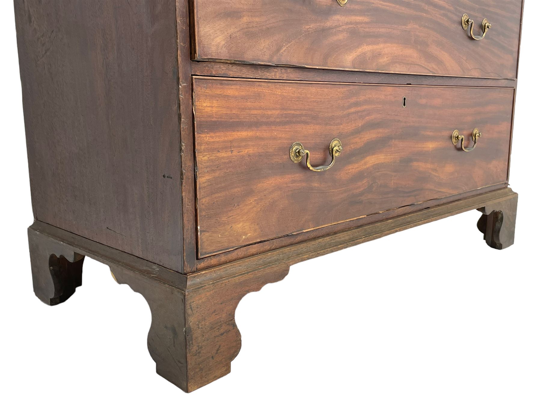George III mahogany Gentleman's linen press, the projecting cornice over two panelled cupboard doors enclosing three sliding trays, the base fitted with two short over three long graduating cock-beaded drawers, lower moulded edge over bracket feet