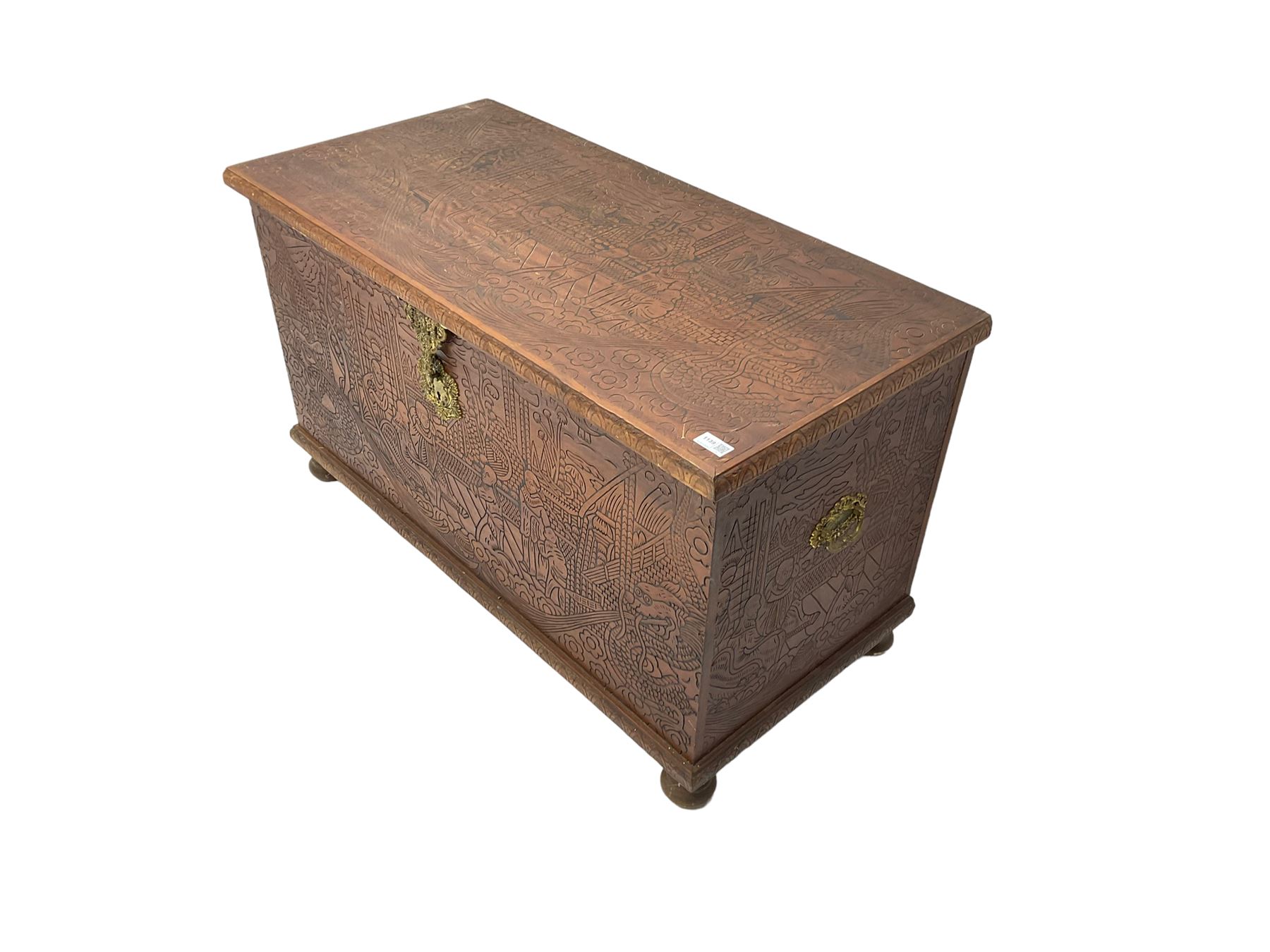 Hong Kong camphor wood chest, rectangular hinged top, carved all over with traditional scenes and dragon boats, on bun feet