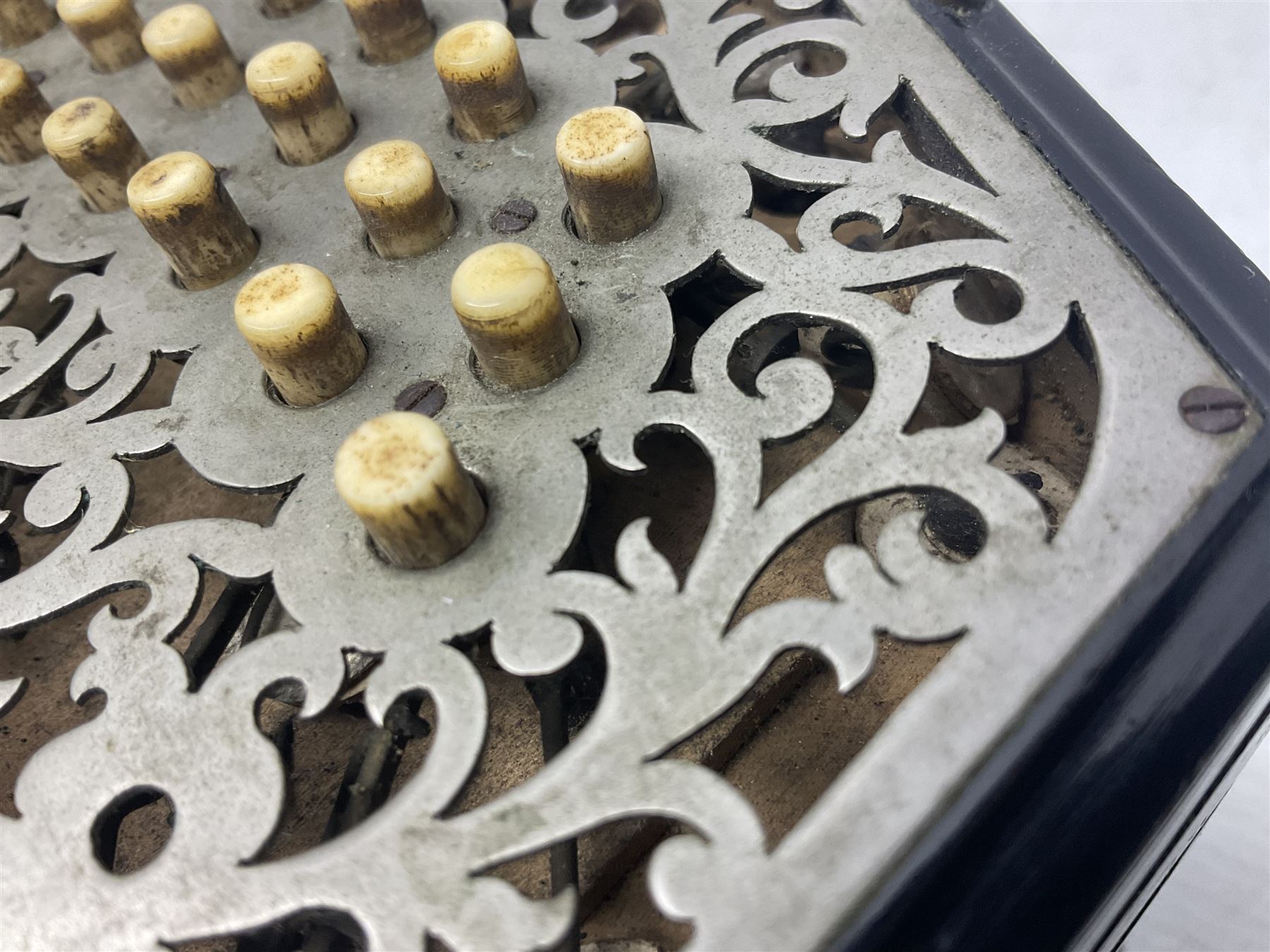 19th century Lachenal concertina of hexagonal form with fretworked nickel ends and thirty-four plus one bone buttons; straps marked Lachenal & Co Makers London and wooden handle stamped English Make Trade Mark L16cm