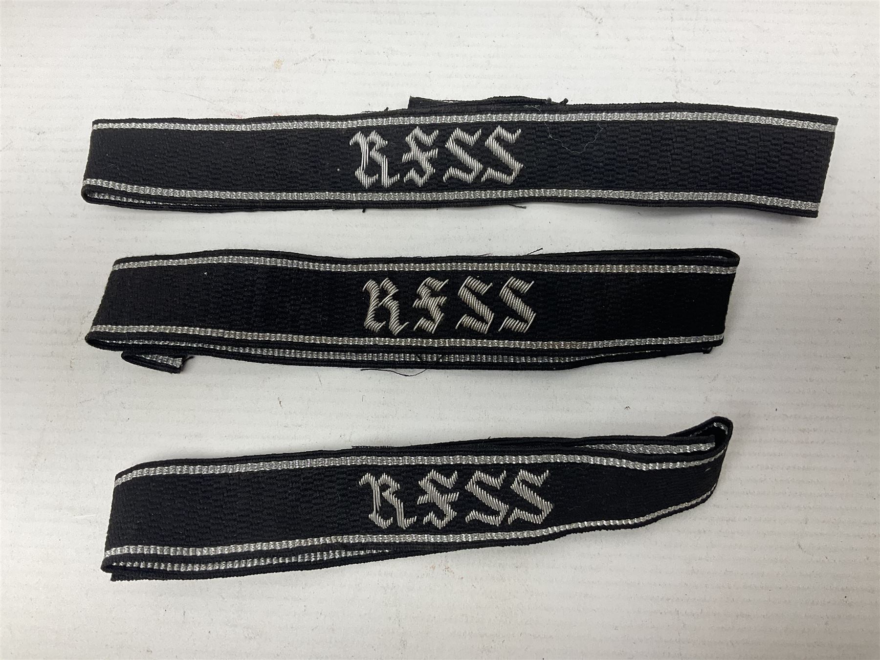 Three Reichsfuhrer 'SS' cuff titles; RZM 'SS' paper tag; German Water Police belt buckle; Destroyers badge marked RKS verso; N.S.B.O. lapel badge; and incomplete party eagle cap badge (8)