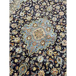 Persian Kashan indigo ground carpet, floral pattern light blue ground central medallion and spandrels, the fielding decorated with interlacing leafy branches and palmettes, the repeating floral pattern border enclosed within guard stripes