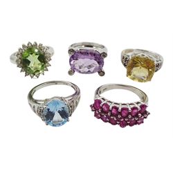 Five silver stone set rings including amethyst and white topaz, Swiss blue and white topaz, ruby, green quartz and white topaz and quartz and garnet, all stamped or tested