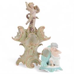 Sitzendorf centre piece, topped with a cherub above three shells upon scrolling feet, toge...