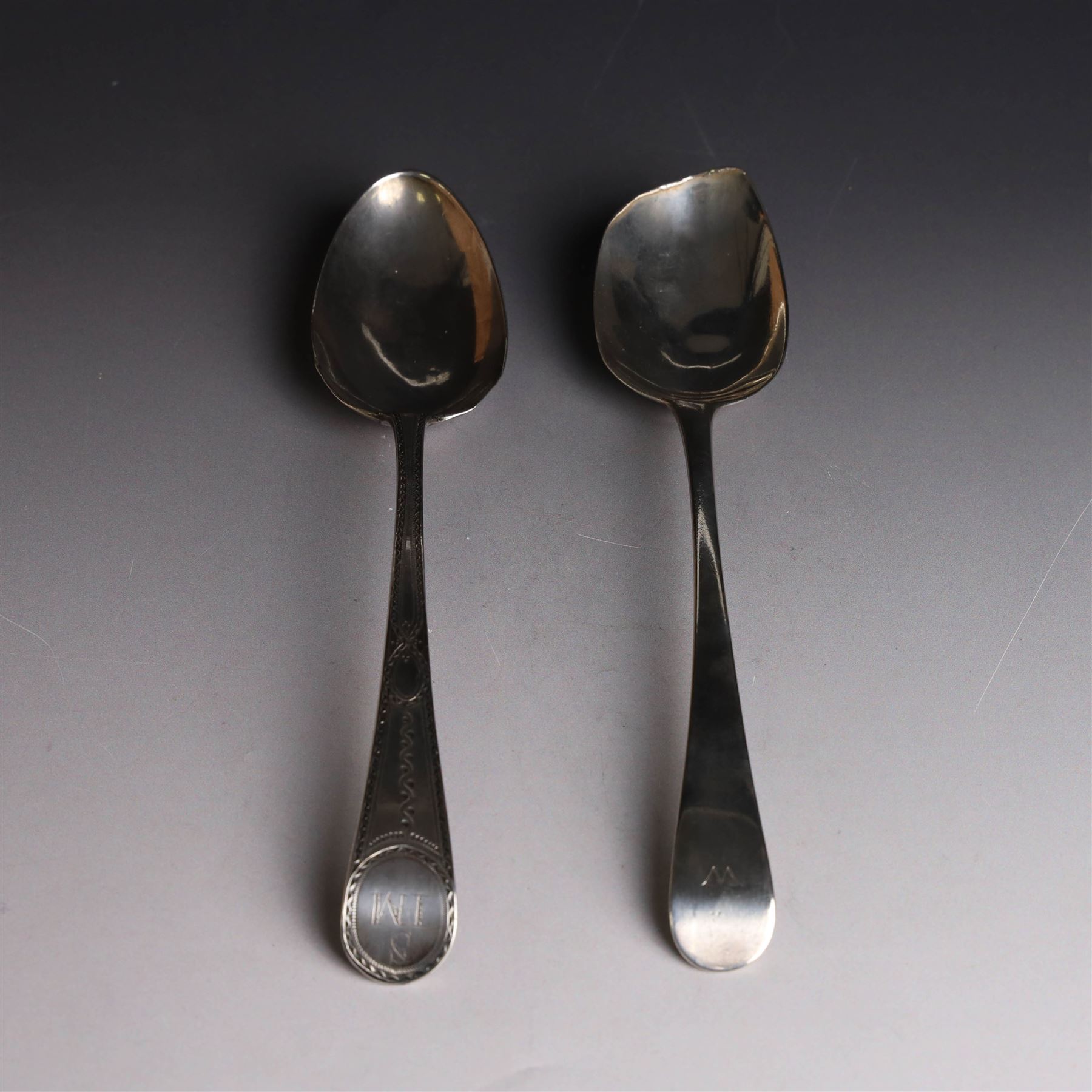 George II silver Old English pattern table spoon, with engraved initial W to terminal, hallmarked Thomas Northcote, London, probably 1758 date mark worn, together with a George III Old English pattern table spoon with bright cut decoration and engraved initials, hallmarked London 1783, makers mark TE probably for Thomas Evans