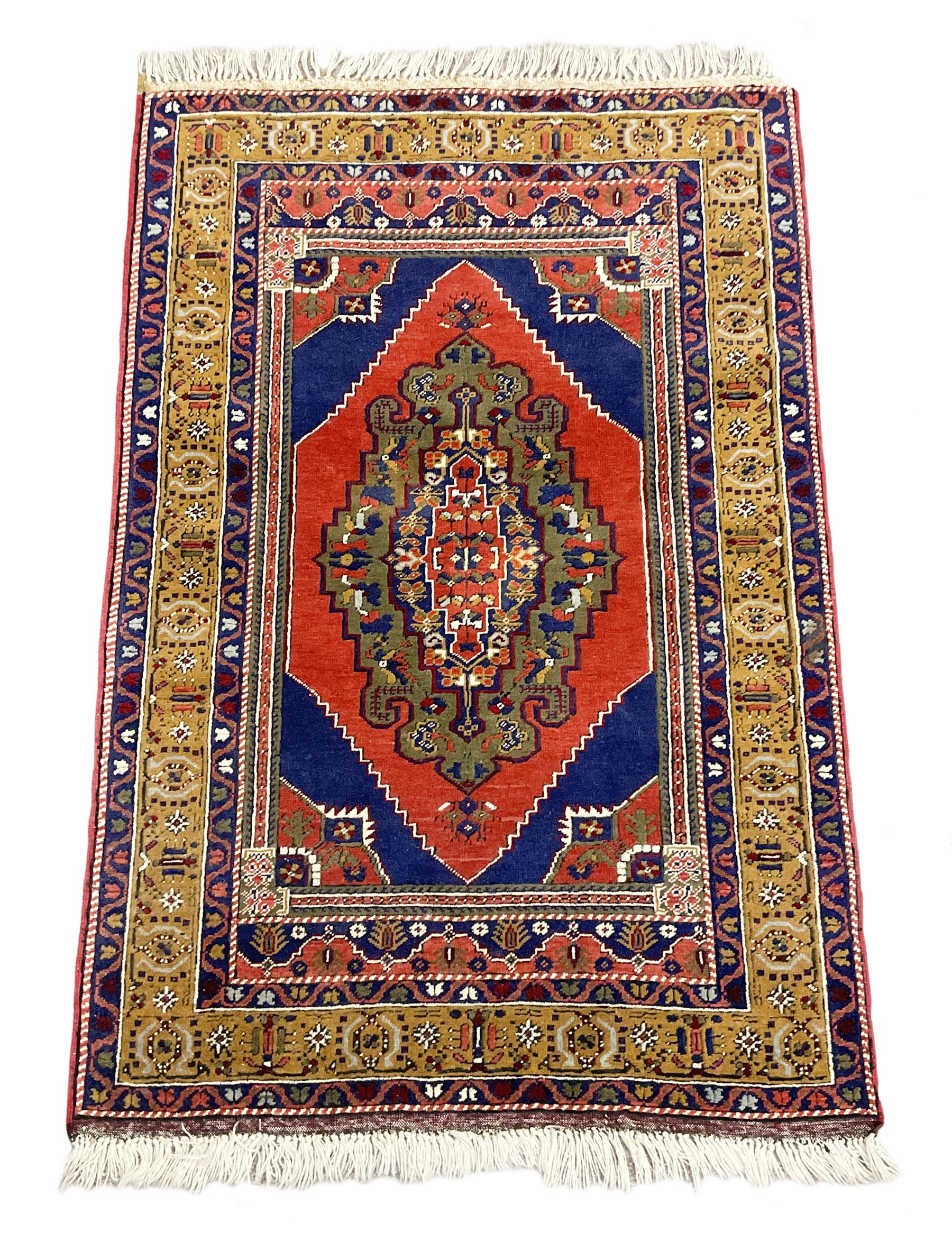 Turkish Taspinar rug, blue ground with central lozenge and medallion, the outer borders decorated with stylised motifs