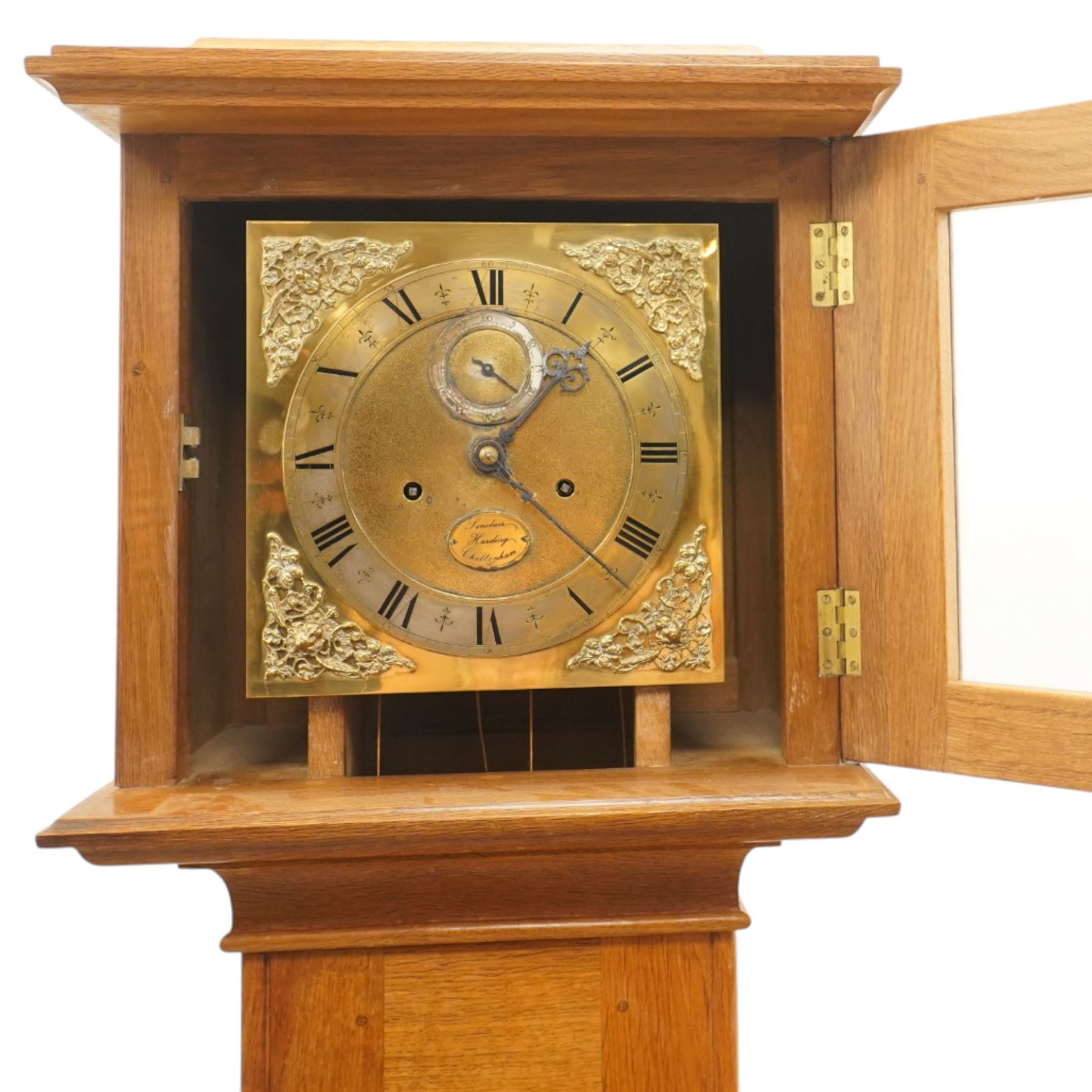 Mouseman - mid-20th century oak longcase clock, with a high quality weight driven movement and dial by Sinclair and Harding & Co of Cheltenham, the rectangular hood carved with foliate ornament, over a glazed and oak trunk on stepped base, with carved mouse signature, by the workshop of Robert Thompson of Kilburn Provenance: purchased directly from the Kilburn workshop in the 1940s/1950s