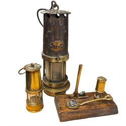 Miners lamp, with plaque numbered 173, together with a miniature brass miners lamp and a wooden paperweight with applied brass miners lamp, pick axe and shovel