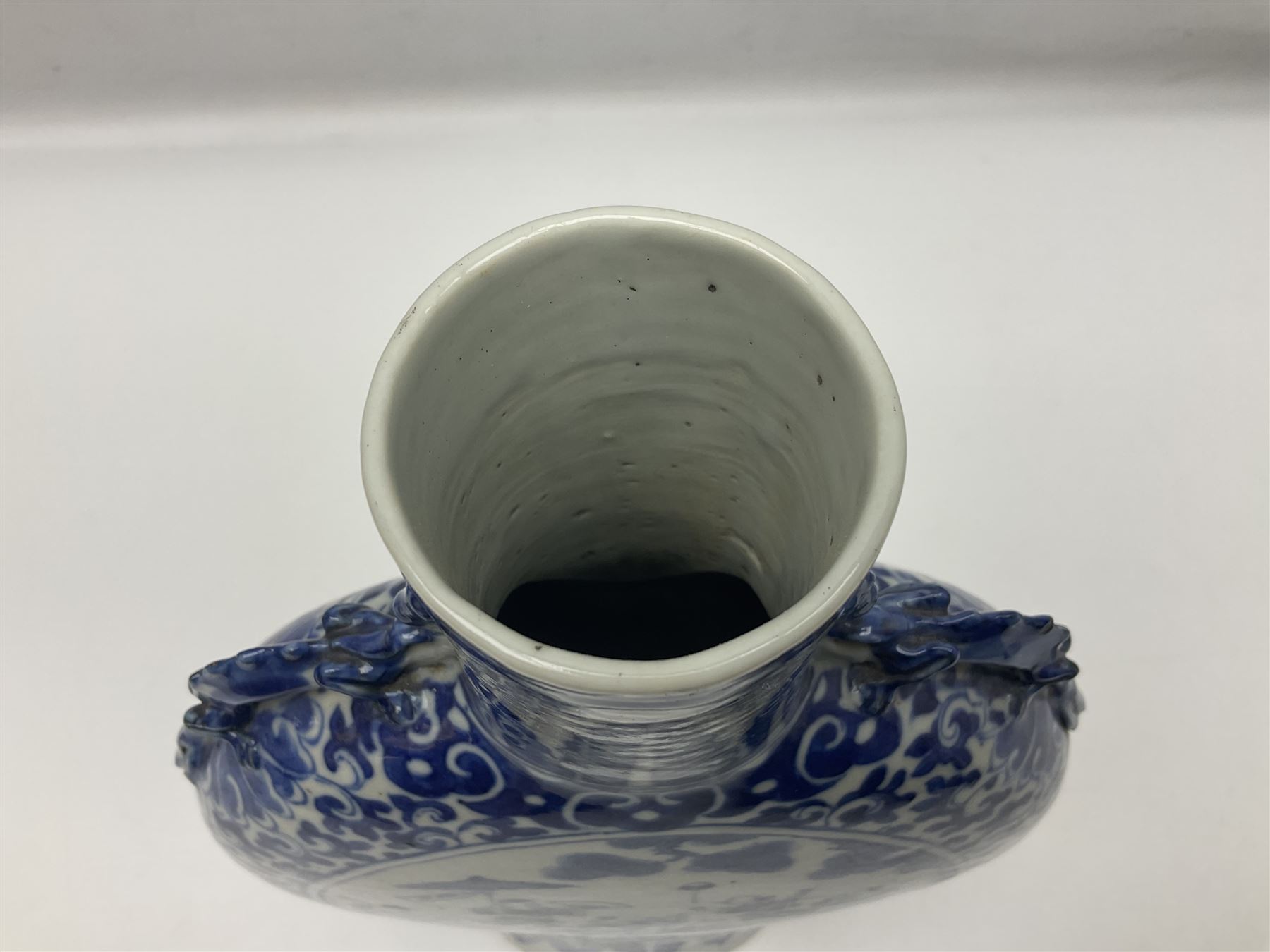 19th century Chinese blue and white moon flask vase, the central panel depicting musicians, bordered by floral, foliate and scroll decoration, with lizard handles to each shoulder, upon an oval foot, H31cm 