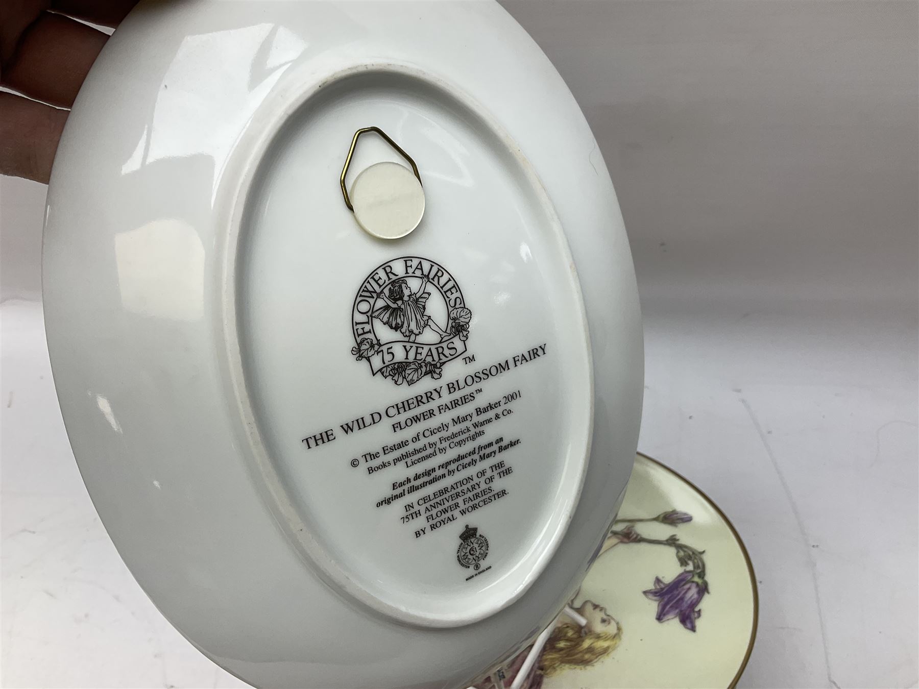 Royal Worcester Flower Fairies oval collectors plates, Goebel mustard pot, two Danbury Mint Fairy Tale bells, and pair of Hutschenreuther candlesticks decorated with scenes of Puss in Boots