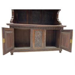 Early 20th century oak buffet side cabinet, the raised back with moulded top over two drawers, three panel back and two cupboards under, raised on turned supports, profusely carved with foliate all over W123cm, H126cm, D49cm
