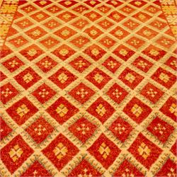 Moroccan Berber hand knotted runner, the red and orange ground woven with an all over lattice of lozenge motifs enclosing small geometric devices, within narrow patterned borders, finished with fringe to one end