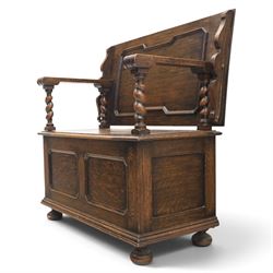 Early 20th century oak monks bench, panelled back converting to a table top, reeded armrests with barley twist uprights, hinged seat over panelled base supported on bun feet
