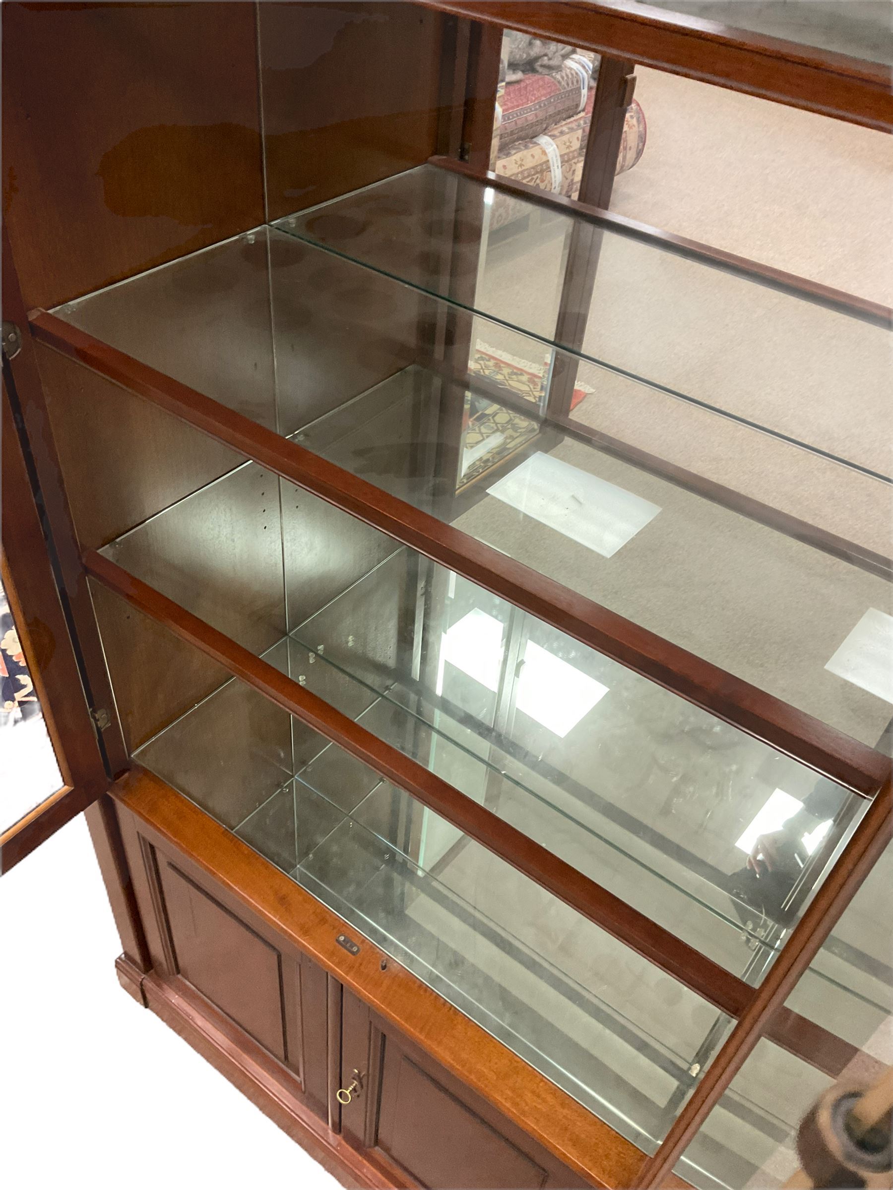 Grange Furniture - cherry wood finish display cabinet, two bevel glazed doors enclosing mirrored interior with glass shelves, double panelled cupboard below, on plinth base
