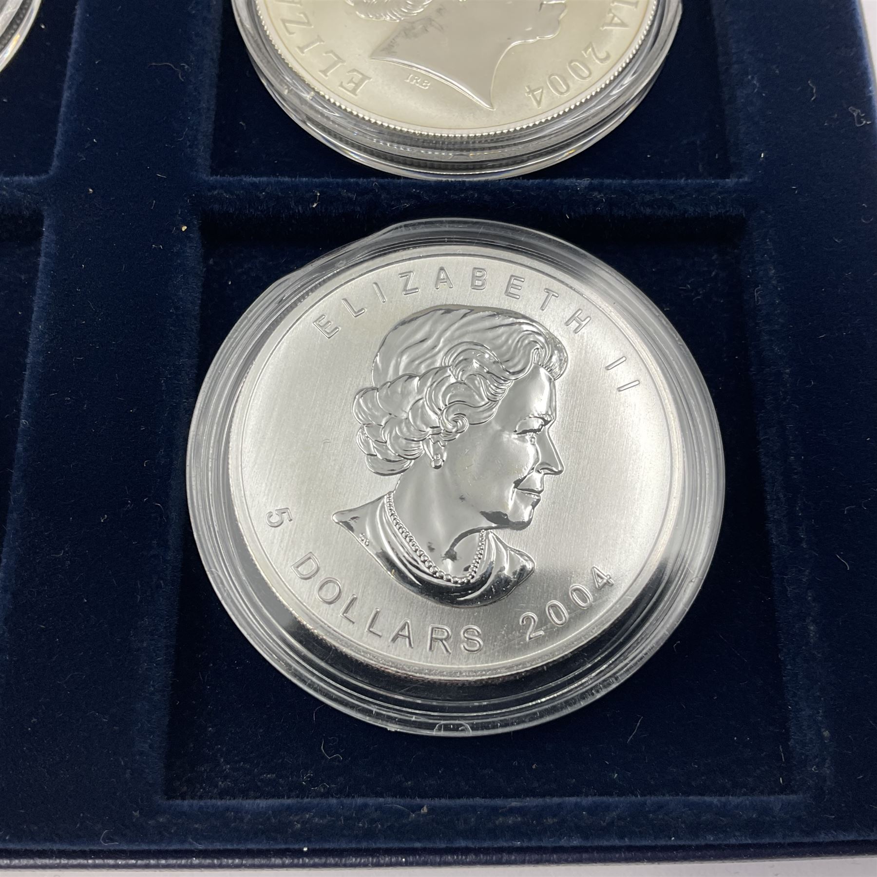 Four one ounce fine silver coins, forming 'The 2004 Famous World Silver Coin Collection', comprising United States eagle, Australian kangaroo, Chinese panda and Canadian maple leaf, cased with Westminster certificate 