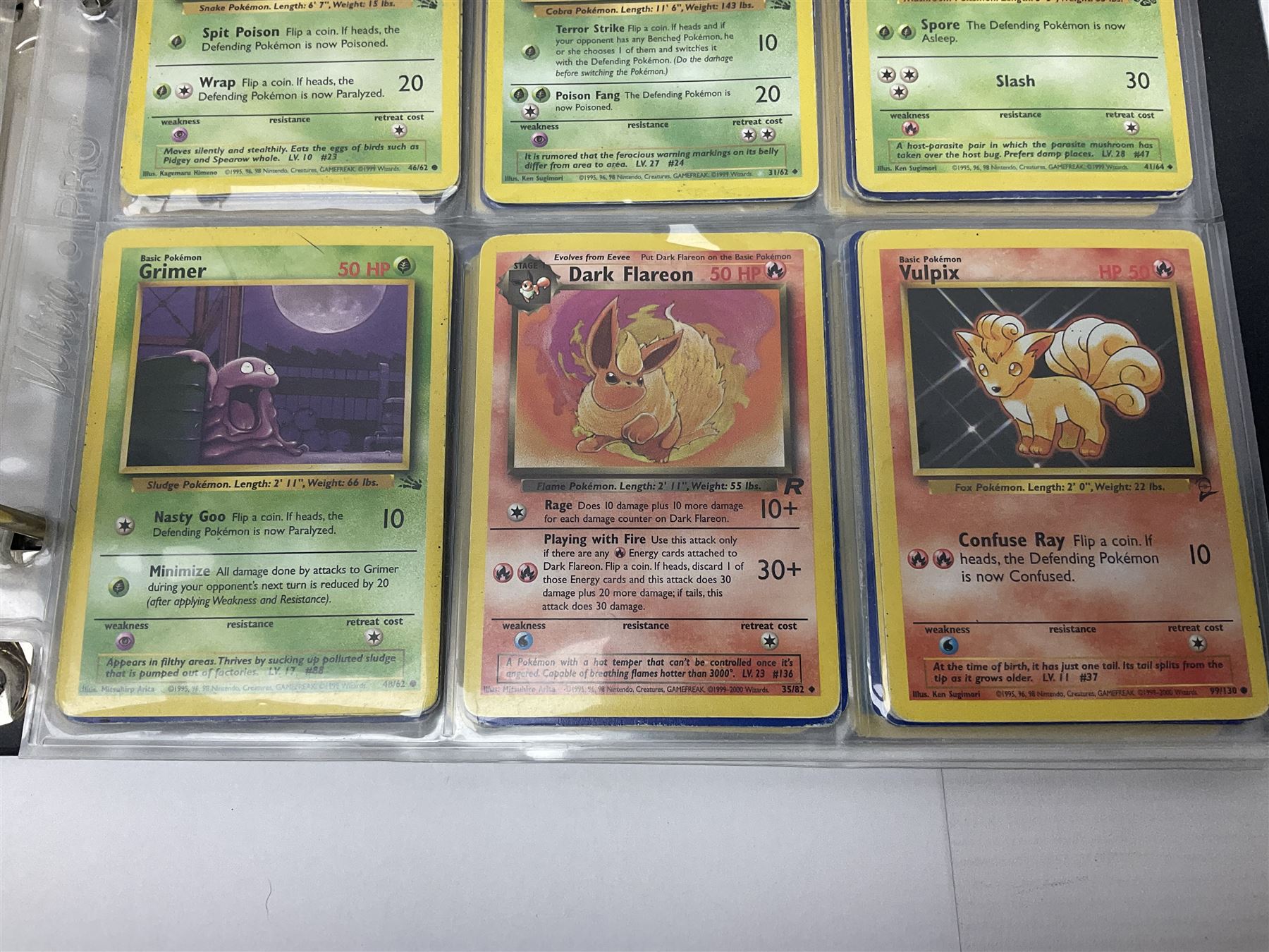 Collection of Pokemon trading cards, mostly 1999 Wizards Pokemon cards to include holo Charizard 4/102, first edition holo Machamp 8/102, further holographic cards; Dark Flareon 35/82 and Dark Vaporeon 45/82, cards from themed sets and 4th edition prints; 1998 Electronic Pokédex with cardboard boxes for themed decks Blackout, Overgrowth and Power Reserve Jungle, along with a large quantity of energy and trainer cards 