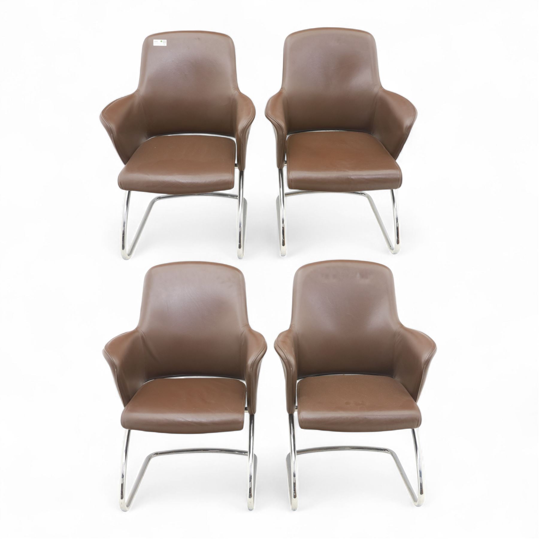 Four Senator executive cantilever chairs, upholstered in Padova hide, moulded back and integrated armrests, raised on a tubular chromed cantilever base
