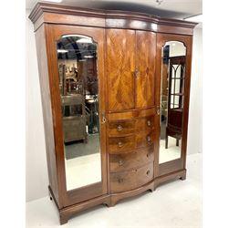 Edwardian inlaid mahogany triple wardrobe, bow front centre with two cupboards above four graduating drawers flanked by two bevel edged mirror doors, shaped platform base 