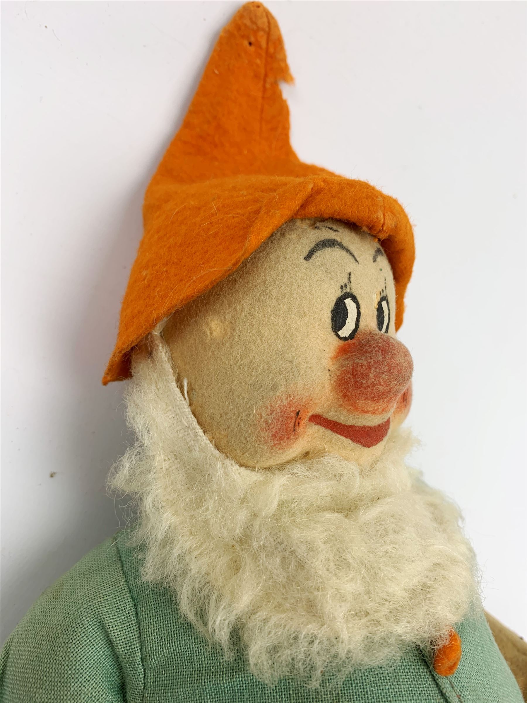 Chad Valley pressed felt figure of the Disney Snow White dwarf 'Doc' with painted facial features, standing wearing a green linen suit with orange hat, belt, buttons and shoes H13