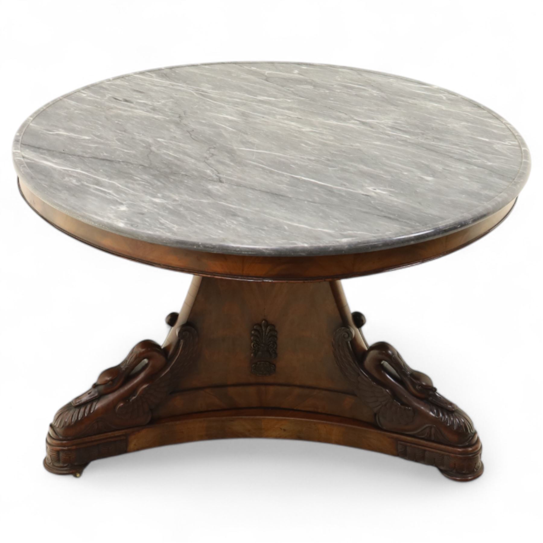 French mid-19th-century Second-Empire mahogany centre table with a dished grey-veined marble top, on a tapered triform pedestal with anthemion brass mounts above carved recumbent swan figures with delicately refined wings and graceful necks curving backwards, associated with the Empress Josephine, raised on three small platform bases