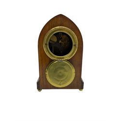 Early 20th century mahogany Lancet shaped mantle clock with an American “Ansonia” eight-day striking movement, case with oval fan inlay and stringing, two recessed brass pilasters, shallow plinth raised on bun feet, movement striking the hours and half hours on a coiled gong, enamel dial with Arabic numerals, minute markers and steel spade hands, within a convex glass and spun bezel. With pendulum 