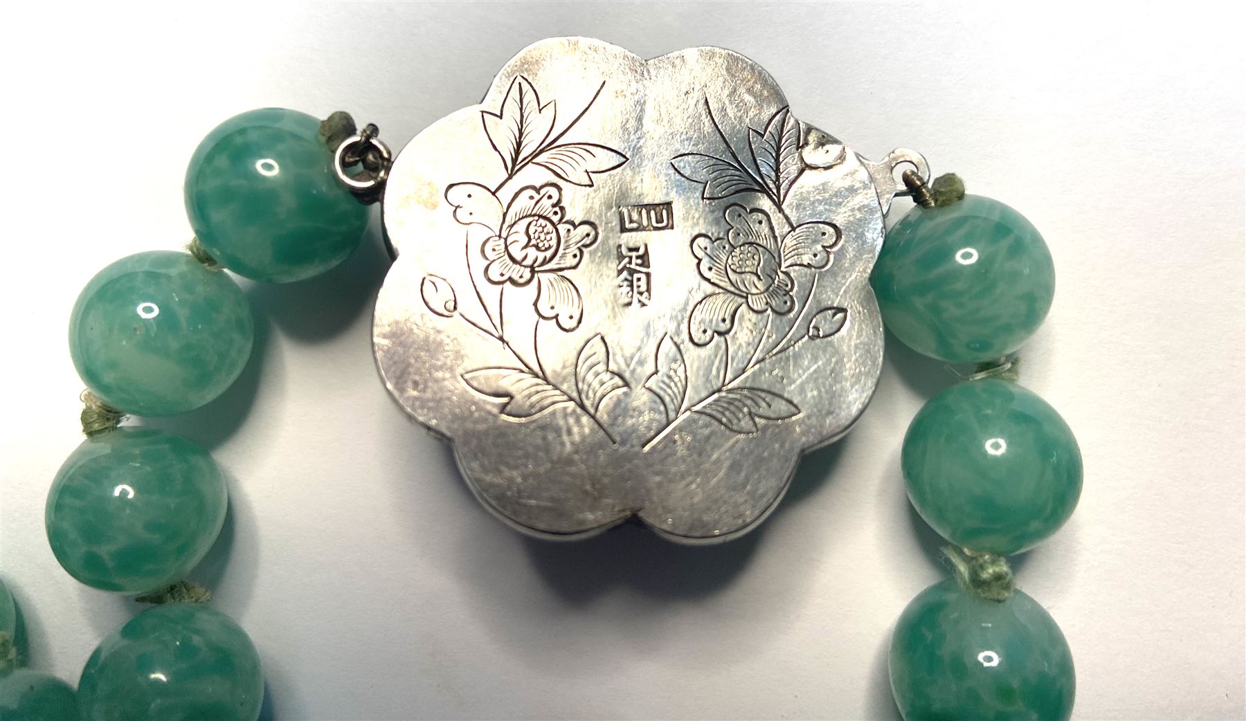 Chinese jade bead necklace with silver open work clasp with a cabochon greenstone/possibly jade bead necklace, signed Liu with Chinese character marks