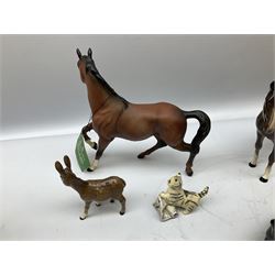 Three Beswick figures, comprising black labrador no 1956, donkey no 2267 and donkey foal no 2110, together with three Royal Doulton figures, one of a cat with a newspaper and two bay horses  