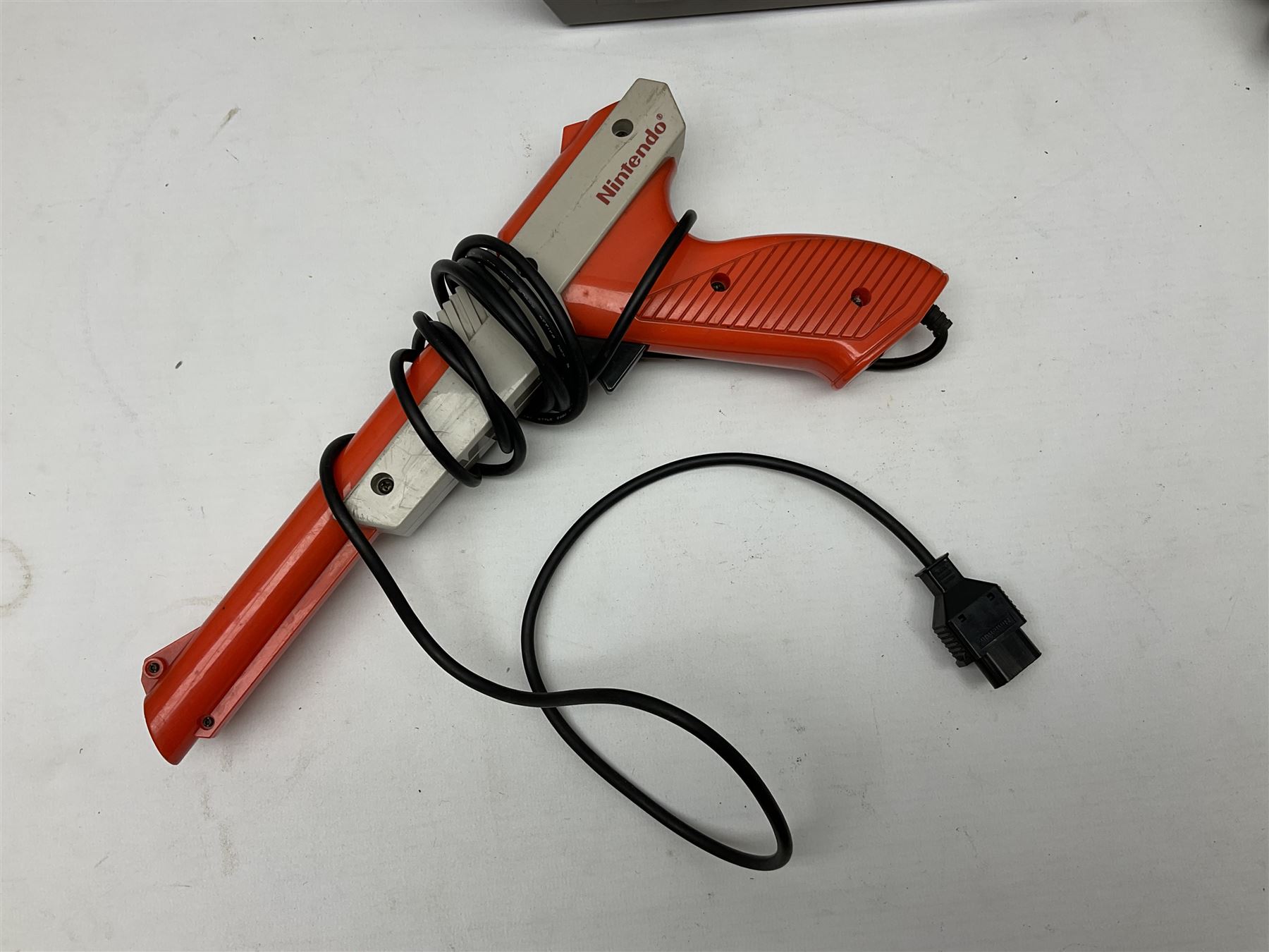 Nintendo Entertainment System (1985) console with two controllers, accessories and instruction booklet. NES Games ‘Duck Hunt’ with Nintendo Zapper gun, ‘Pinball’ and ‘Super Mario Bros.’, all with original sleeves and instruction booklets. NES game ‘Super Mario Bros. 2’ cartridge only