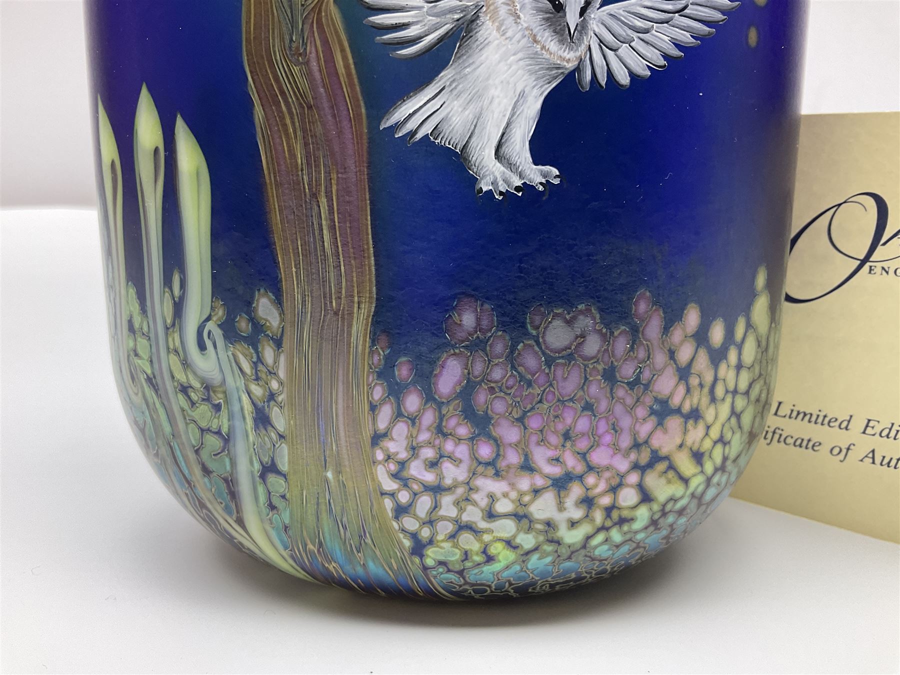 Okra limited edition glass vase, Night Owl, no 19/50, designed by Terri-Louise Colledge, of oval form, painted with a barn owl taking flight amongst leafy branches, upon an iridescent blue ground, etched marks and dated 2002 beneath, with limited edition certificate, H16.8cm, unboxed 