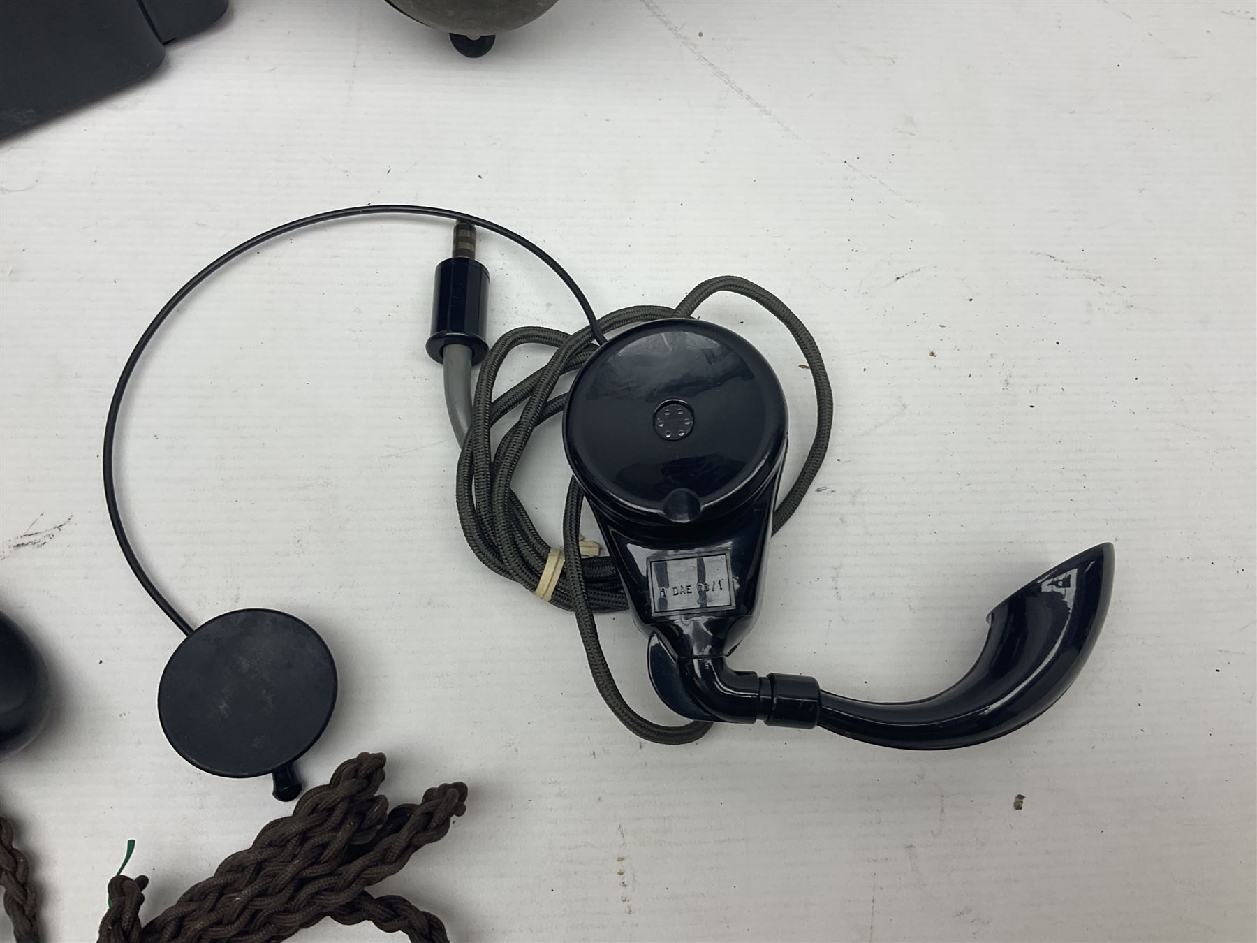 Collection of phone headsets, including GPO bakelite examples, together with other telephone parts 