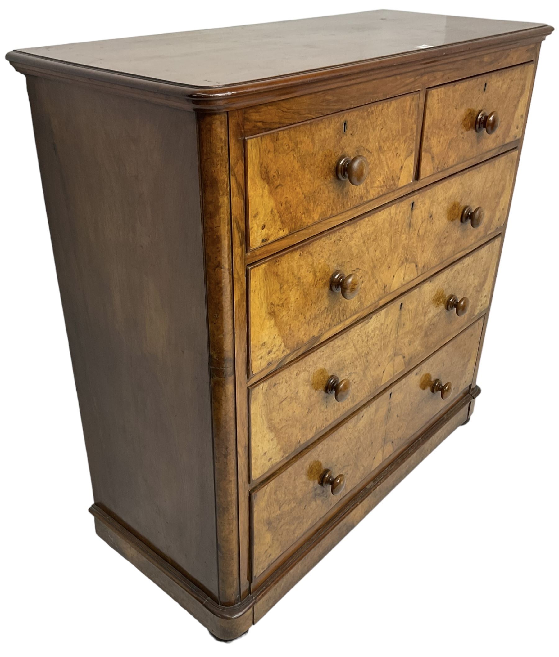 Early 20th century figured walnut chest, fitted with two short over three long drawers with bookmatch veneer facias, each with turned walnut handles, skirted base over compressed bun feet 