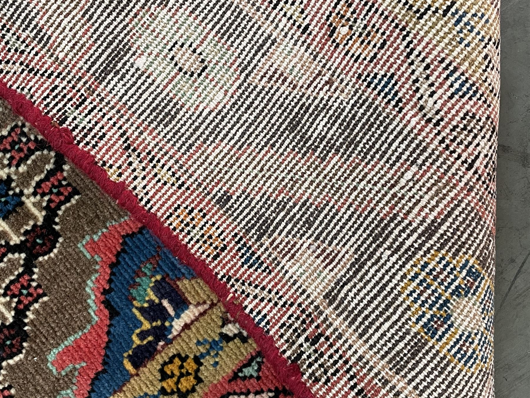 Persian Hamadan rug, the rosette pole medallion on a pale field decorated with stylised motifs, the blue band border decorated with stylised flower heads
