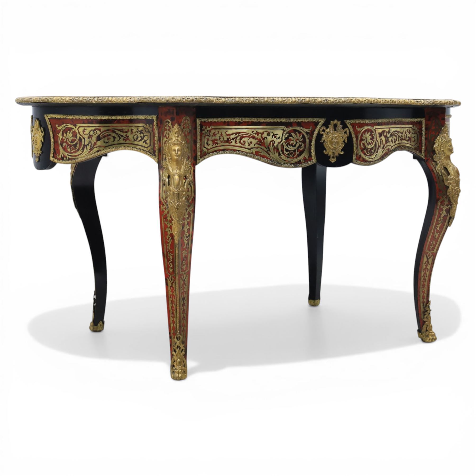 Late 19th century boulle work centre table, shaped serpentine top decorated with brass inlay on red tortoiseshell ground within ebonised border, fitted with single frieze drawer, on cabriole supports with gilt metal mounts and mask terminals