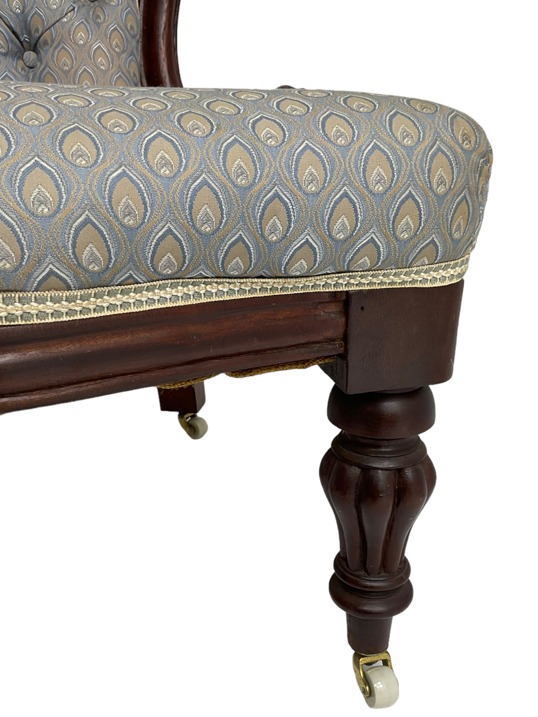 Victorian walnut framed open armchair, scrolled arm terminals over spiral turned arm supports, upholstered in foliate patterned fabric with sprung seat, on turned supports and brass castors (W65cm H92cm); and Victorian mahogany nursing chair with lobe carved supports (W60cm H92cm)