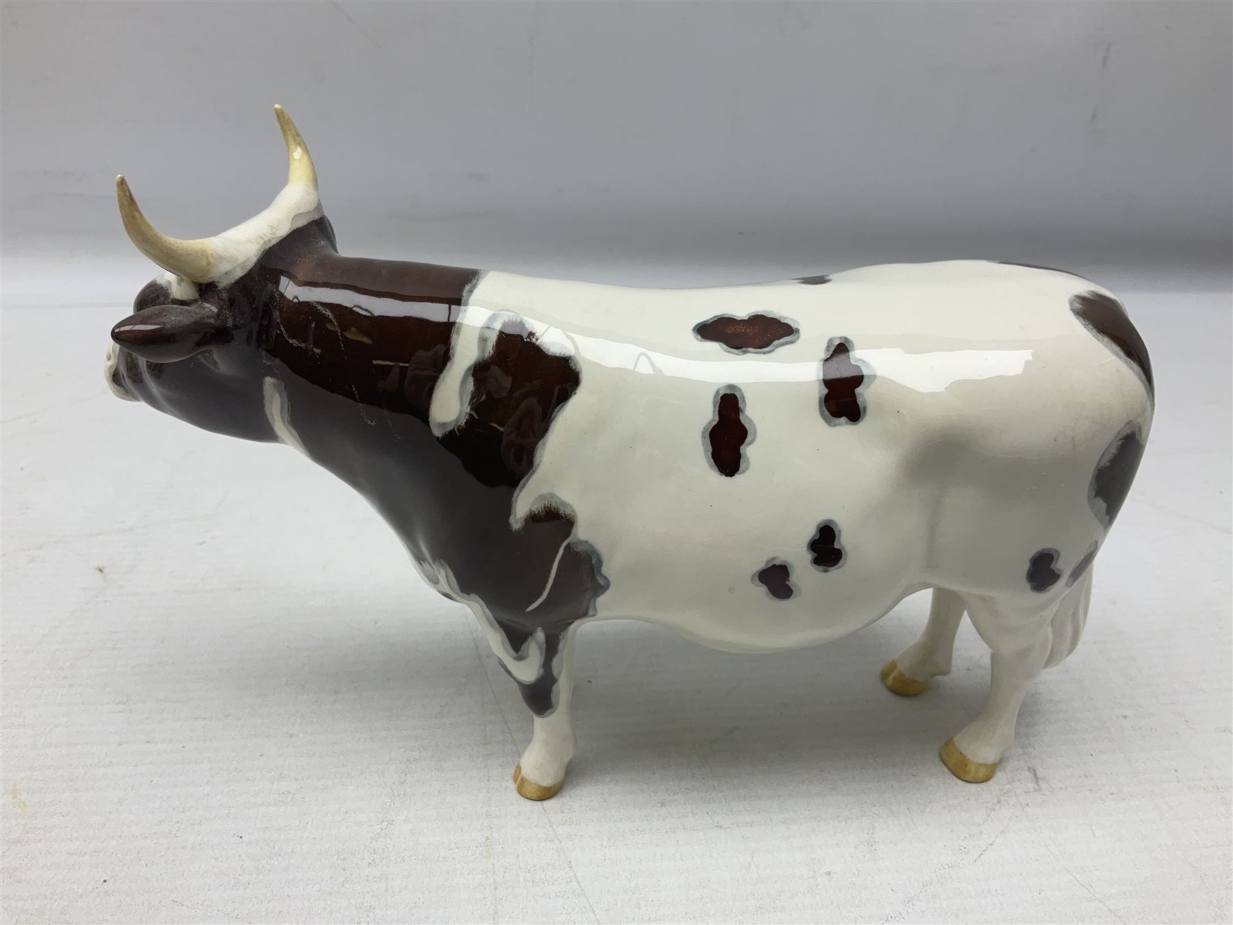 Five Beswick figures of cattle Comprising Ayrshire Bull Ch Whitehill Mandate, no 1454B, three Ayrshire Cow Ch Ickham Bessie, no 1350 and Ayrshire Calf, no 1249B, all with printed marks beneath
