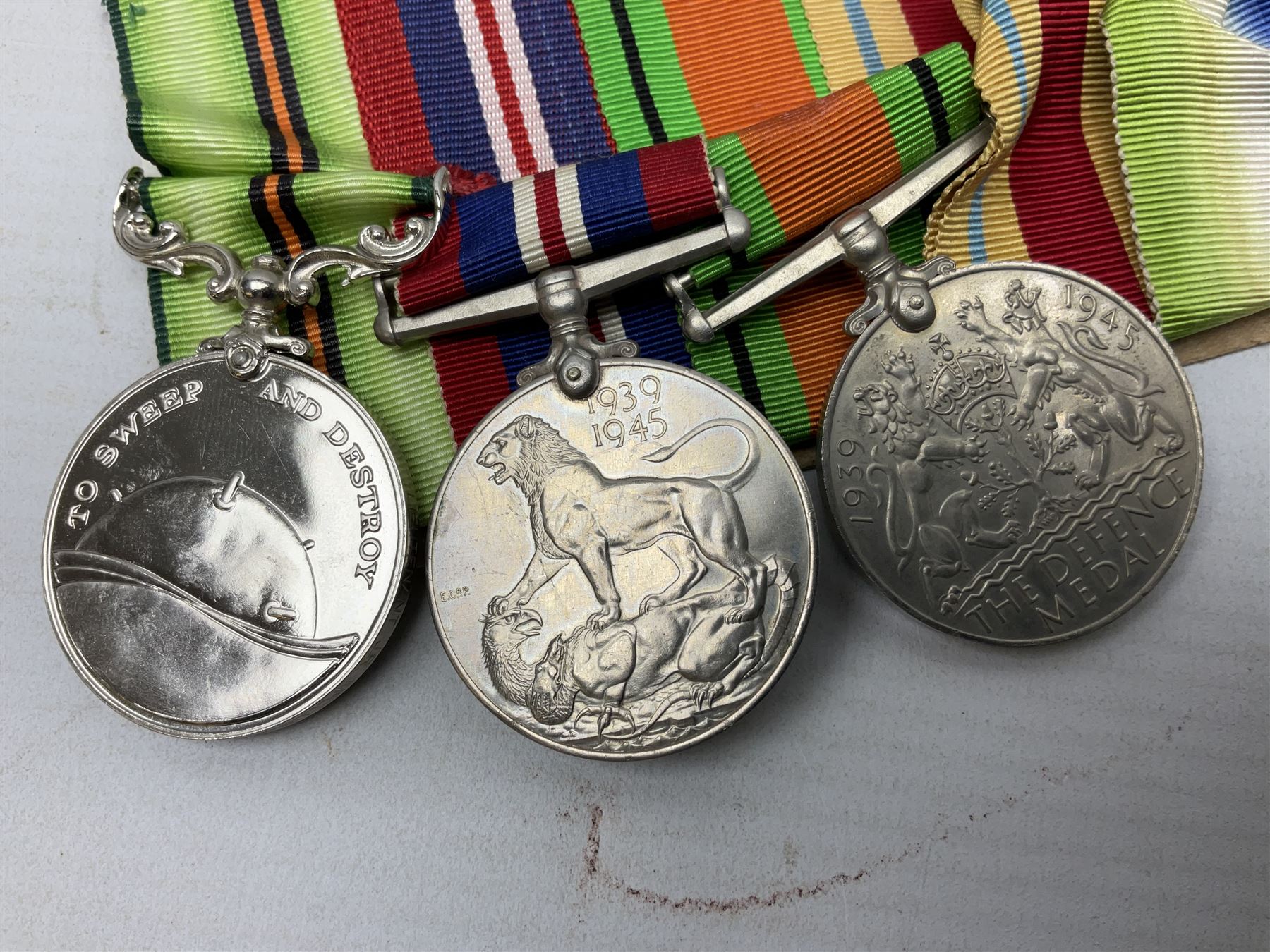 WW2 Royal Naval group of eight medals comprising OBE, hallmarked silver Distinguished Service Cross inscribed verso Lieut. J.R. McCluskie RNVR 1945, 1939-1945 Star, Atlantic Star, Africa Star, 1939-1945 War Medal, Defence Medal and Royal Naval Patrol Service Medal inscribed Lieutenant J.R. McCluskie Royal Naval Patrol Service; with seven original photographs of a sea battle 27th November 1940 against the Italian Fleet and another photographic postcard of Sir Stafford Cripps arriving on board one of the vessels.