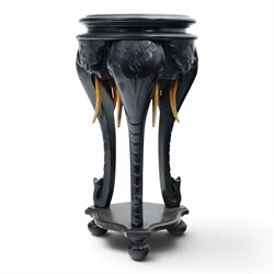 Elephant ebonised jardinière, moulded circular top raised on carved Elephant supports unit...