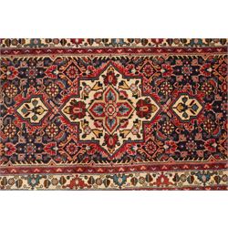 North-west Persian Malayer runner rug, the indigo ground decorated with ivory medallions and an all-over Herati pattern, red floral spandrels, enclosed by an ivory trailing floral border and crimson patterned guard stripes